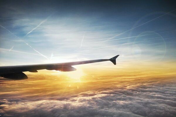 A wing from an airplane on the background of sunset