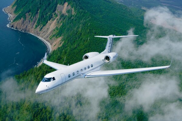 The plane is flying along the seashore