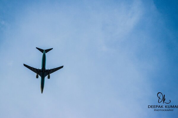 A black plane in a blue sky