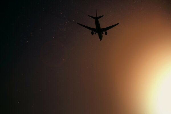 A plane leaving into a bright sunset