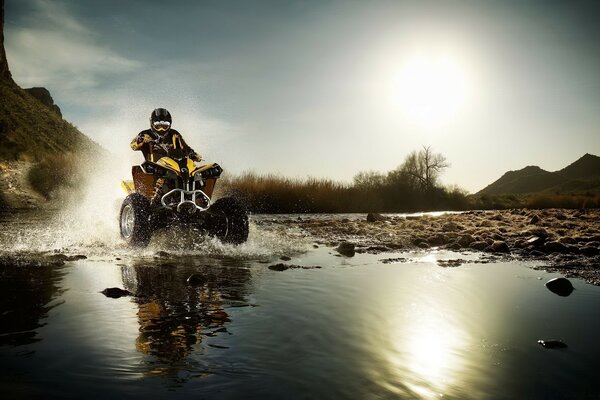 Mann auf einem Quad überwindet Hindernis