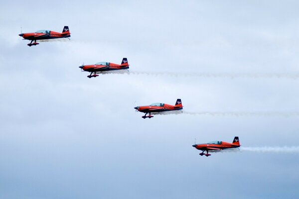 Four red planes are flying