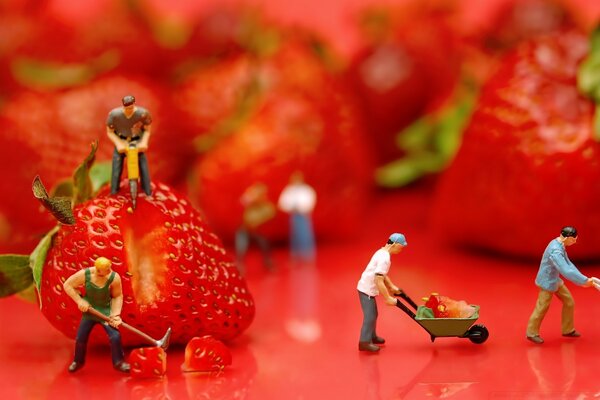 Macro photography toy workers carve strawberries