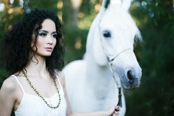 Portrait of a girl with a white horse