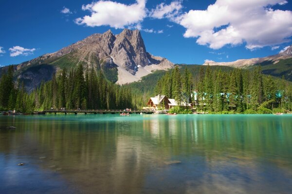 A house in the forest by the lake at the foot of the mountain