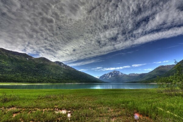 Lago de montaña bajo el cielo azul