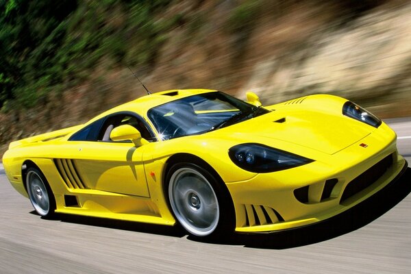 Yellow racing car is flying on the road