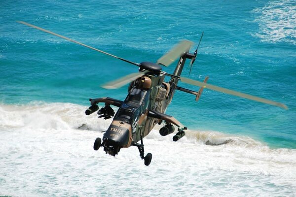 Military helicopter over the blue sea