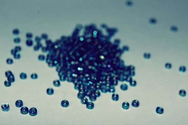 Blue beads scattered on a white surface