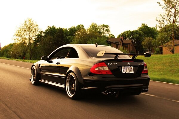 Mersedes CLK 63 with rear anti-wing rushes on a flat asphalt