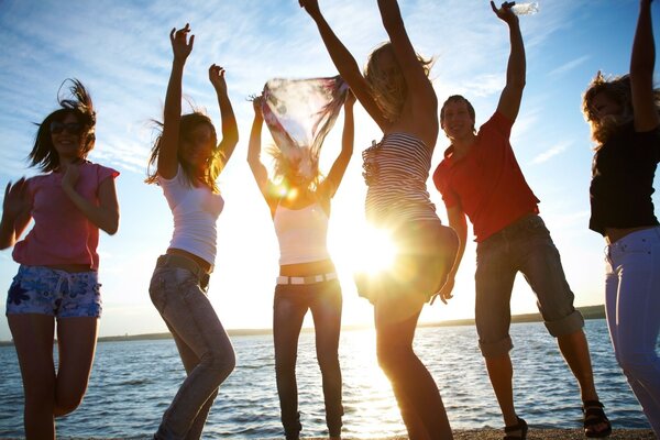 La festa degli amici si svolge in riva al lago con i raggi luminosi del sole