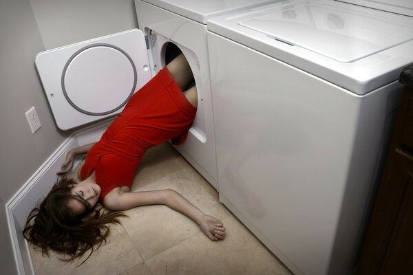 Fille en rouge tombe de la machine à laver