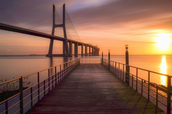 Schöner Sonnenuntergang auf dem Hintergrund der Brücke