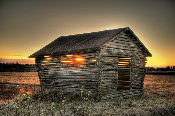 Dawn on the background of an old house in a field