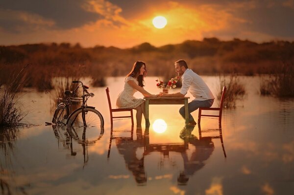 Pareja enamorada al atardecer en la mesa