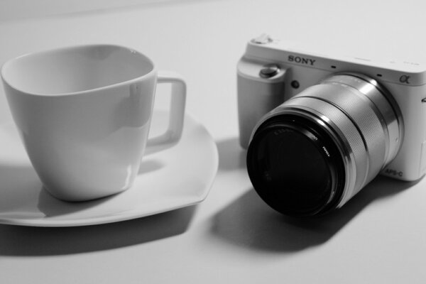 An empty white cup and a Sony camera