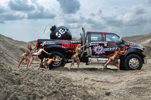 Half-naked girls pushing a big car