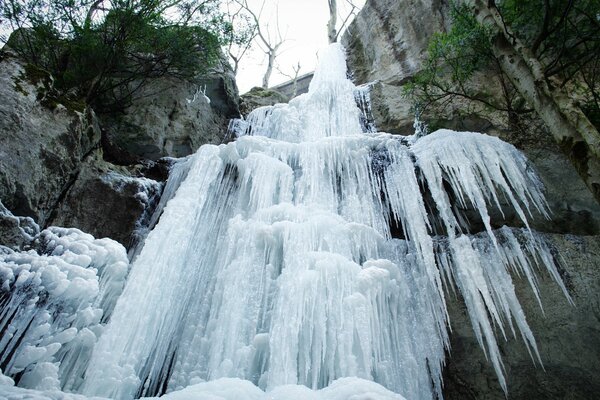 Cascata invernale congelata sullo sfondo delle rocce