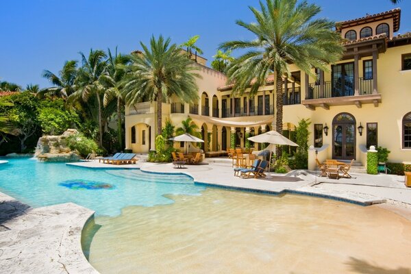 Swimming pool with blue water and sun loungers