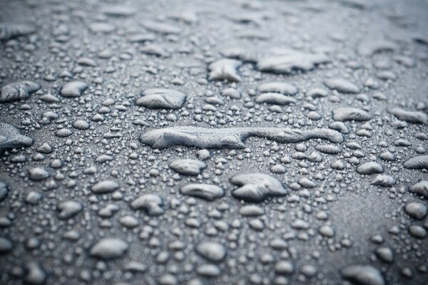 Macro photography of the surface of dry land on which the first raindrops fell