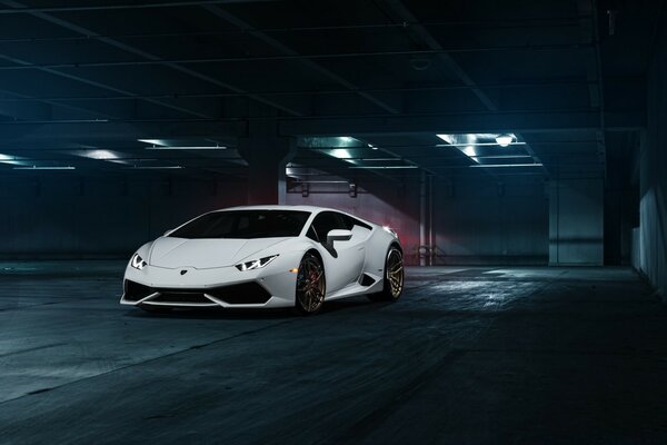 Voiture de course blanche dans un parking souterrain