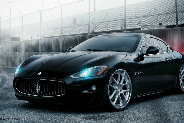 A black car on a gray wall background