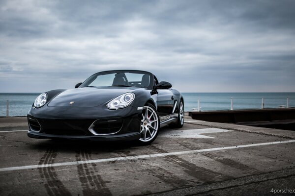 Black Porsche 911 by the water