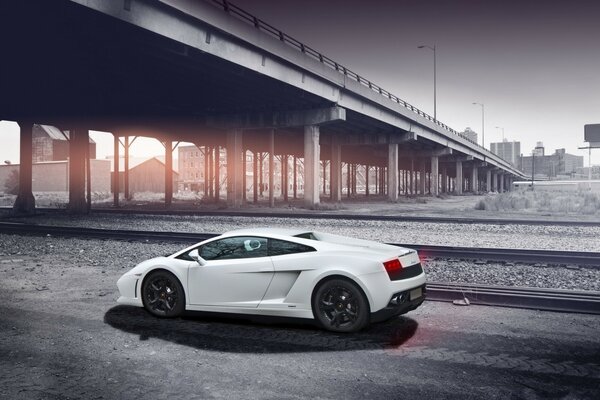 Coche extranjero blanco en el fondo de la vía férrea