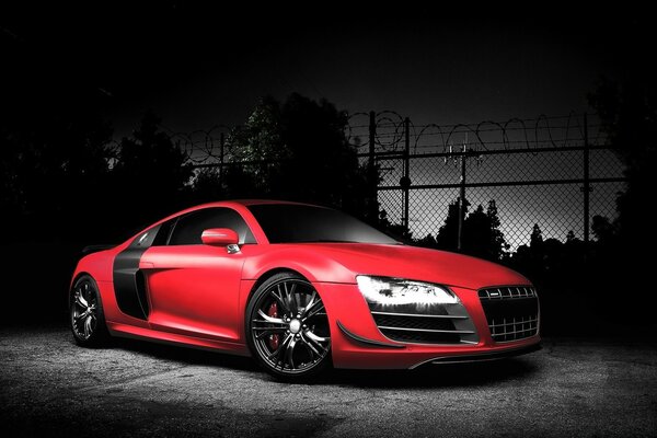 Red audi in a dark forest with dark disks