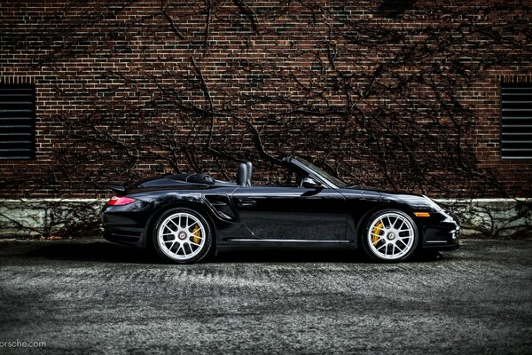 Black Porsche convertible with raised roof