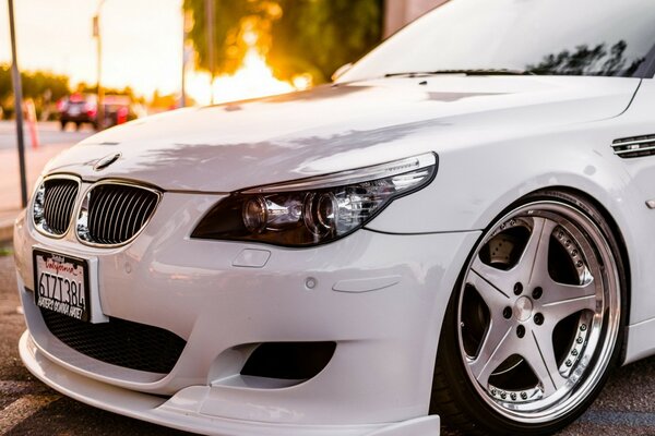 A white car on the background of a sunset city