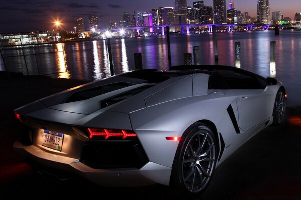 Coche blanco en el fondo de los reflejos de la ciudad en el río