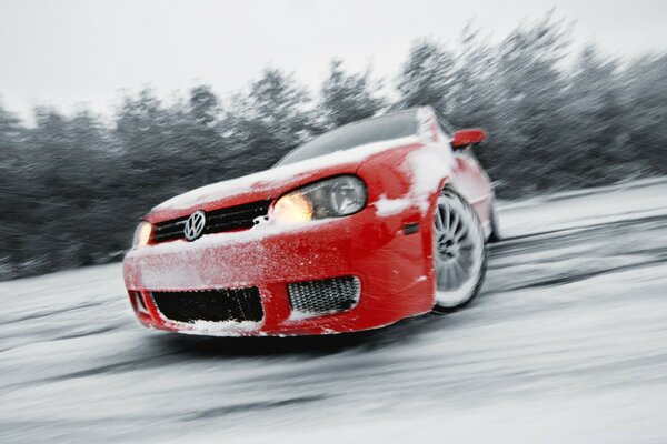 Foto del coche Volkswagen en un camino nevado en la deriva