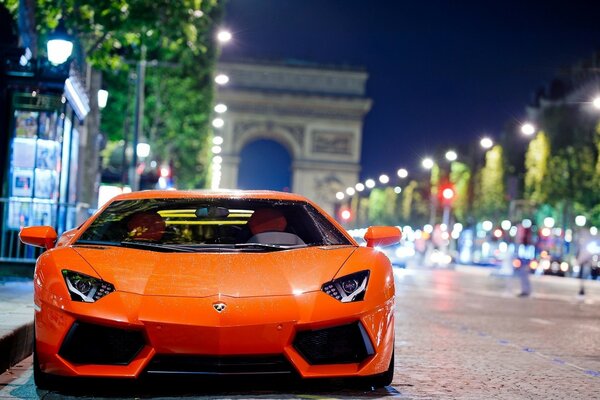 Lamborghini naranja en la ciudad de la noche