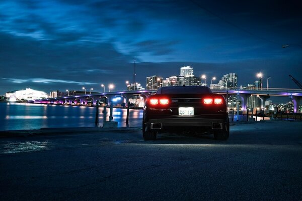 Voiture sur le front de mer et la ville de nuit