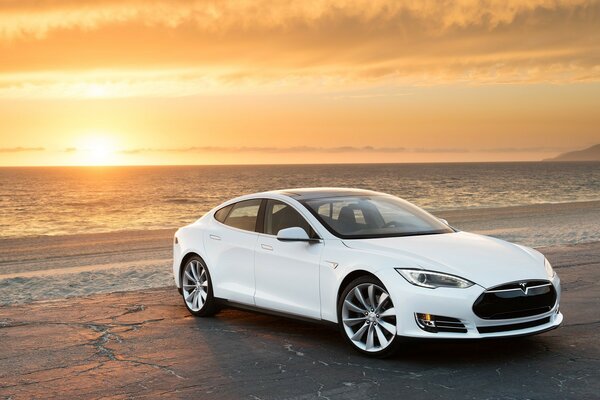 Carro branco na praia ao pôr do sol