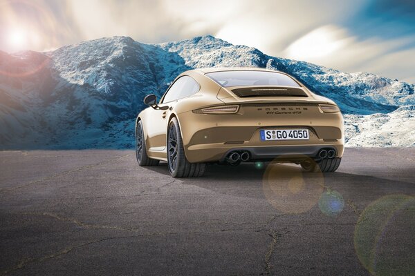 Golden car on the background of snow-capped mountains