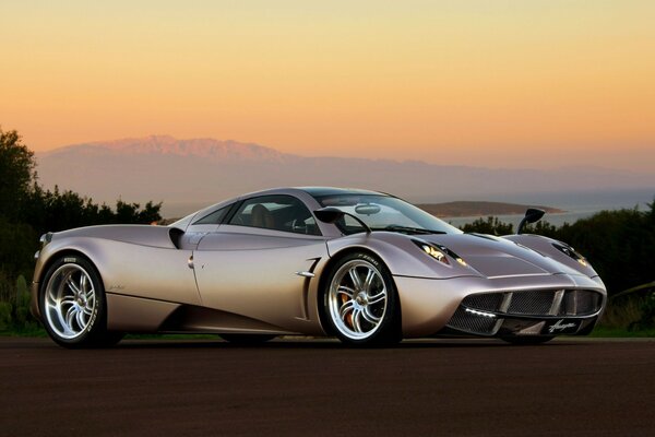 Silver racing car on sunset background