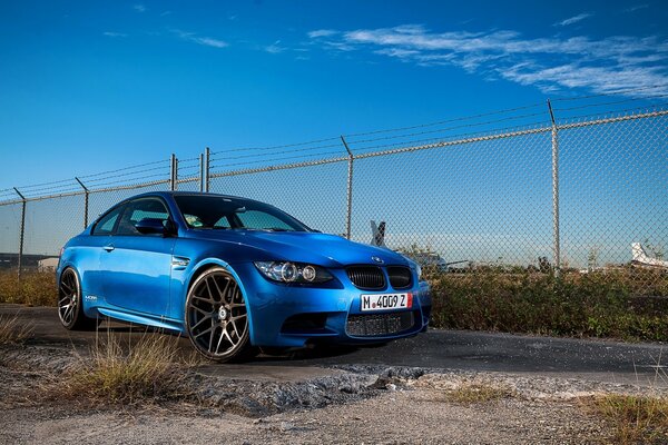 Coche de carreras azul en el fondo del cielo azul