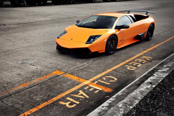 Coche naranja en asfalto gris