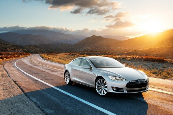 A car rides on asphalt at sunset