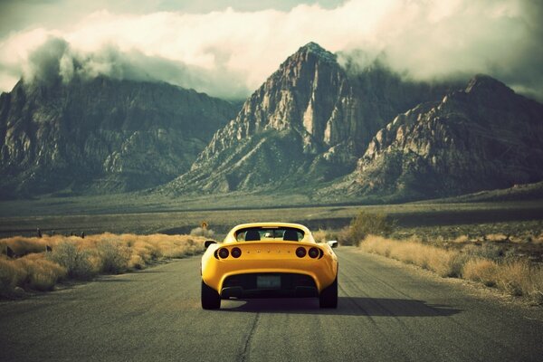 A car on the road. Background with mountains