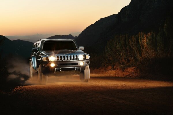 Jeep en mouvement au coucher du soleil dans les montagnes