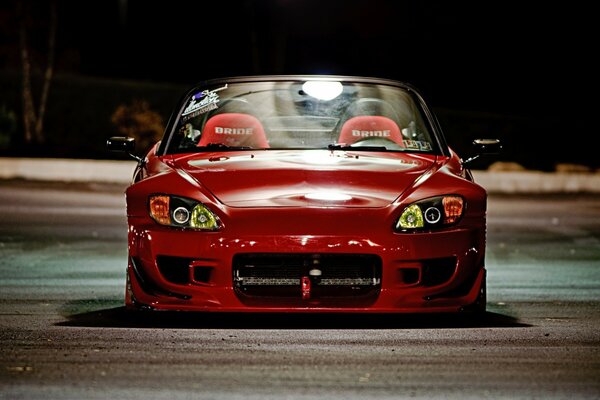 Red car on the road at night