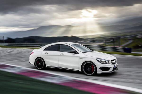 A white car is racing fast on the asphalt