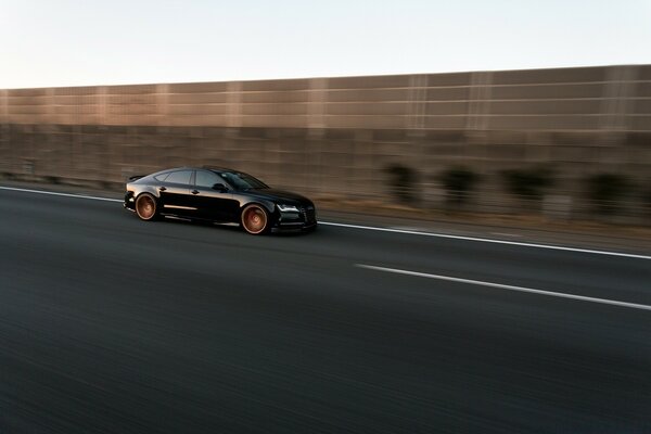 A black car driving on the road