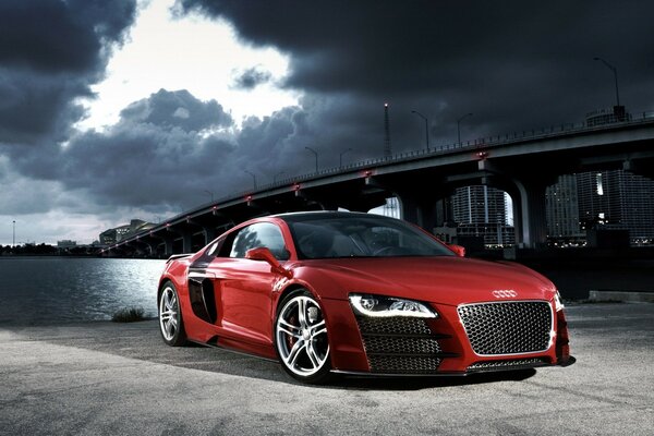 Red Audi standing under the bridge