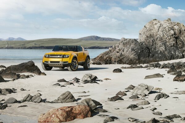黄色的汽车在海滩和岩石的背景