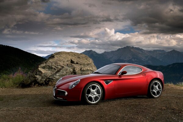 Coche rojo en el fondo del paisaje de montaña