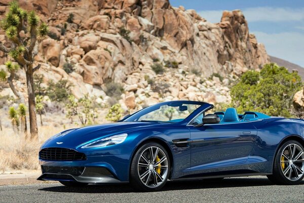 Cabriolet bleu avec Jantes chromées sur fond de montagnes